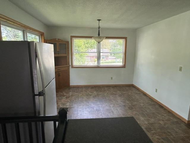 903 3rd Ave, Grand Rapids, MN 55744 - kitchen with freestanding refrigerator, baseboards, and a textured ceiling