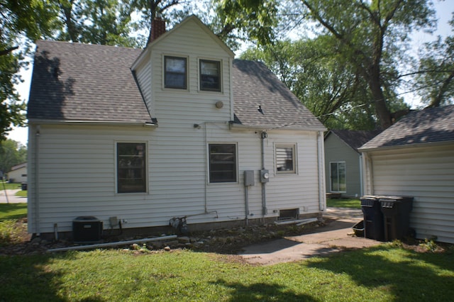 13 S St, Morris, MN 56267 - rear view of property featuring a lawn, a shingled roof, and a chimney