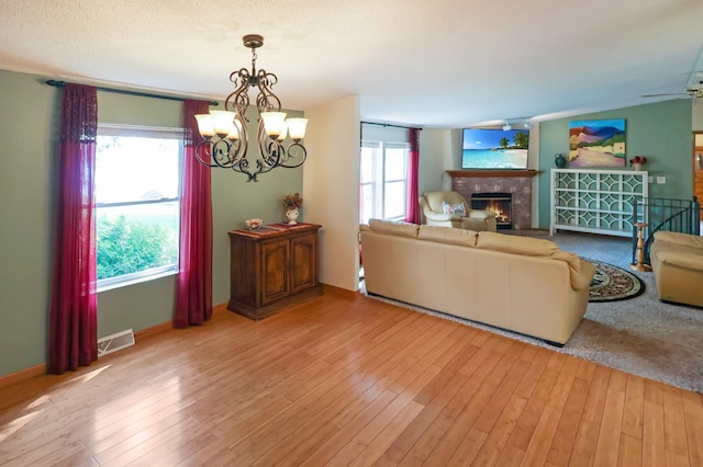 10196 48th St, Clear Lake, MN 55319 - living room featuring a chandelier, wood finished floors, and a lit fireplace