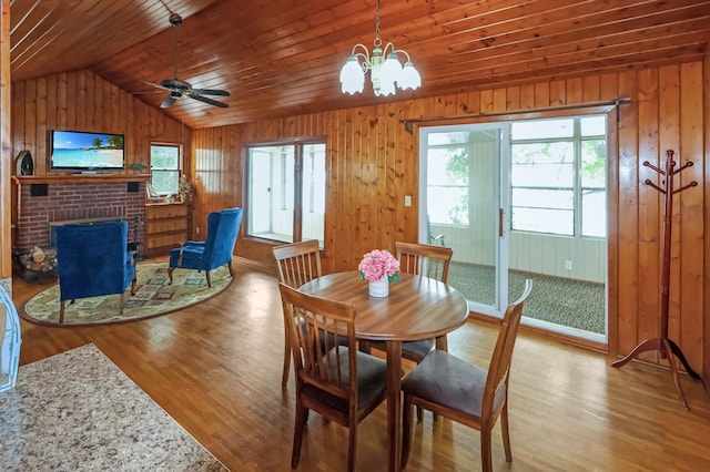 10196 48th St, Clear Lake, MN 55319 - dining room with vaulted ceiling, wood finished floors, wooden ceiling, a fireplace, and wood walls