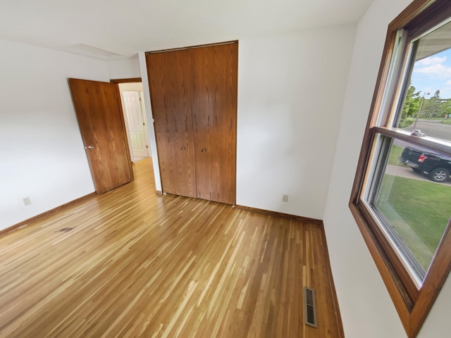8337 80th St S, Cottage Grove, MN 55016 - unfurnished bedroom with light wood finished floors, baseboards, and a closet