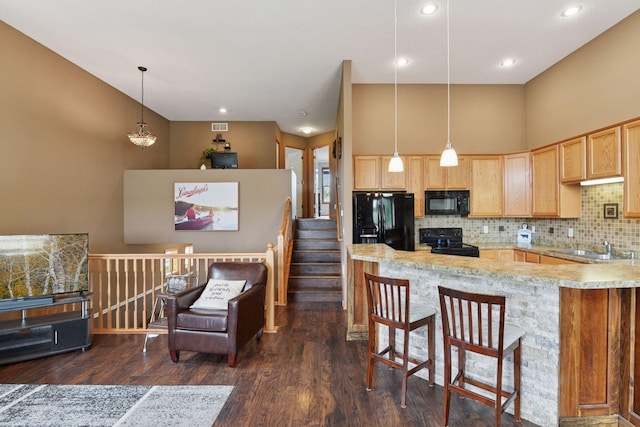 2936 18th Ave E, Shakopee, MN 55379 - kitchen featuring black appliances, light brown cabinets, decorative backsplash, dark wood-style floors, and a kitchen bar