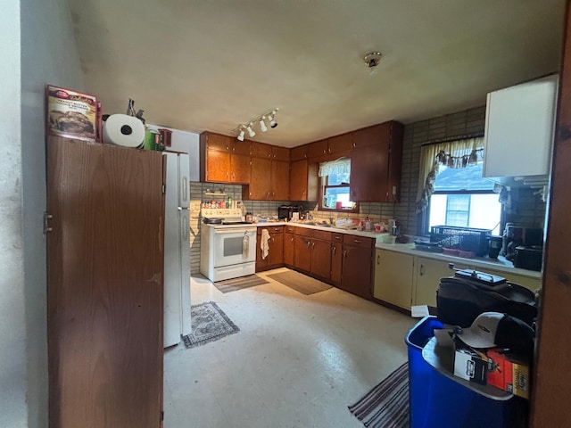609 11th St N, Benson, MN 56215 - kitchen featuring white appliances, tasteful backsplash, light countertops, and brown cabinets