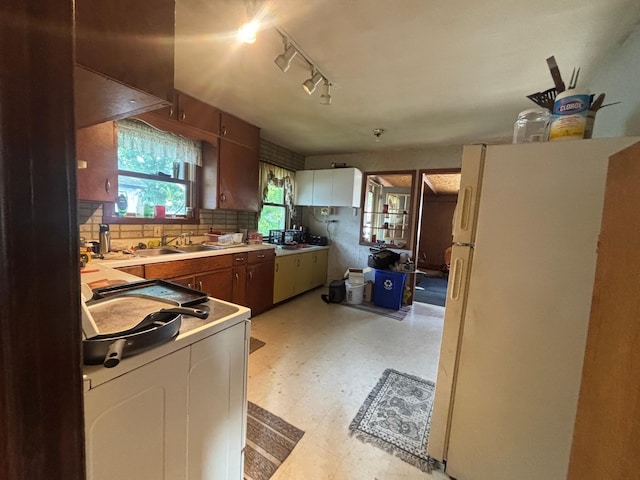 609 11th St N, Benson, MN 56215 - kitchen featuring freestanding refrigerator, light flooring, tasteful backsplash, washer / clothes dryer, and light countertops