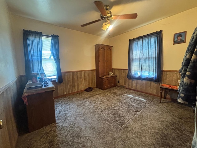609 11th St N, Benson, MN 56215 - unfurnished bedroom featuring wainscoting, wood walls, carpet flooring, and a ceiling fan