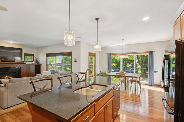 1020 Bliss Ln, Bloomington, MN 55431 - kitchen featuring freestanding refrigerator, light wood-style floors, open floor plan, brown cabinets, and stainless steel dishwasher