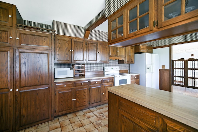 930 Minekahda Pl, Owatonna, MN 55060 - kitchen with white appliances, backsplash, and glass insert cabinets