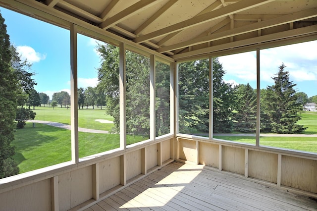930 Minekahda Pl, Owatonna, MN 55060 - unfurnished sunroom featuring lofted ceiling, view of wooded area, and view of golf course