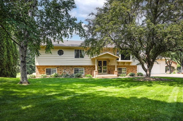 930 Minekahda Pl, Owatonna, MN 55060 - view of front of house with brick siding, a front yard, driveway, and a garage