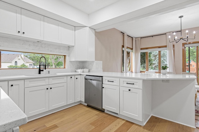 3817 Dunbar Ct N, Brooklyn Park, MN 55443 - kitchen featuring stainless steel dishwasher, a peninsula, light wood-style flooring, backsplash, and a chandelier