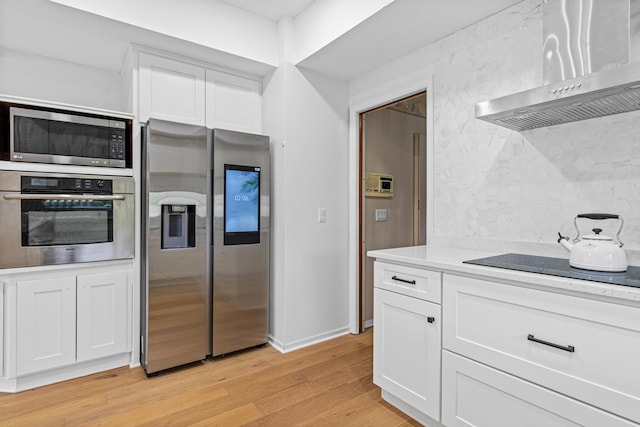 3817 Dunbar Ct N, Brooklyn Park, MN 55443 - kitchen with stainless steel appliances, wall chimney range hood, light wood-style flooring, and white cabinets