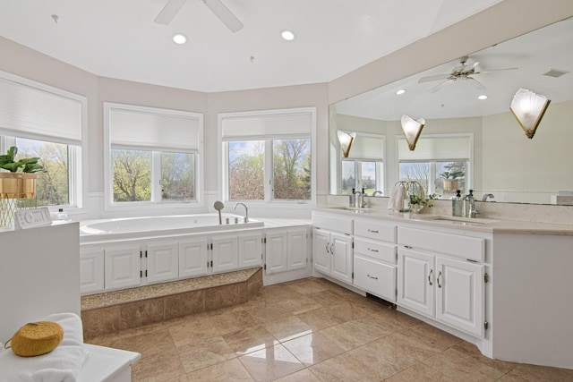 3817 Dunbar Ct N, Brooklyn Park, MN 55443 - bathroom featuring a ceiling fan, double vanity, recessed lighting, and a garden tub