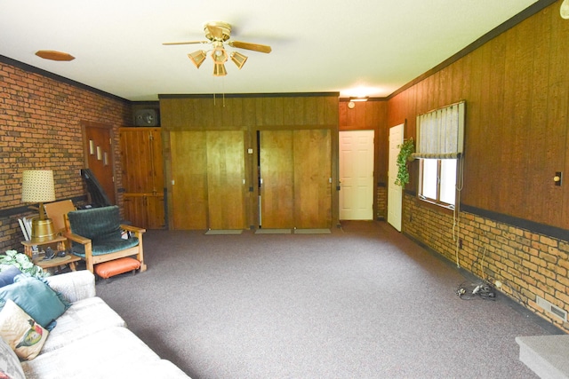 21840 320th Ave NW, Warren, MN 56762 - unfurnished living room featuring brick wall, a ceiling fan, carpet, ornamental molding, and wood walls