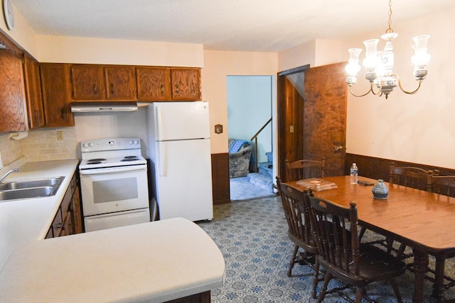 21840 320th Ave NW, Warren, MN 56762 - kitchen with white appliances, ventilation hood, light countertops, a chandelier, and tasteful backsplash