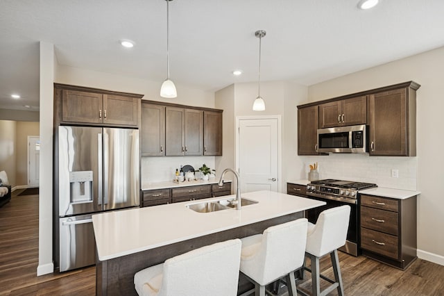1486 Otter Way, New Richmond, WI 54017 - kitchen featuring stainless steel appliances, dark brown cabinetry, backsplash, dark wood finished floors, and recessed lighting