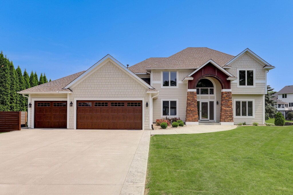 121 Wexford Heights Dr, New Brighton, MN 55112 - craftsman-style house with concrete driveway, an attached garage, a front yard, stone siding, and roof with shingles