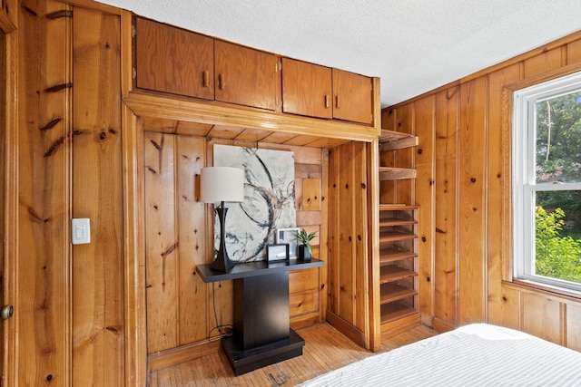 5545 45th Ave S, Minneapolis, MN 55417 - bedroom with wood walls, light wood-style floors, and a textured ceiling