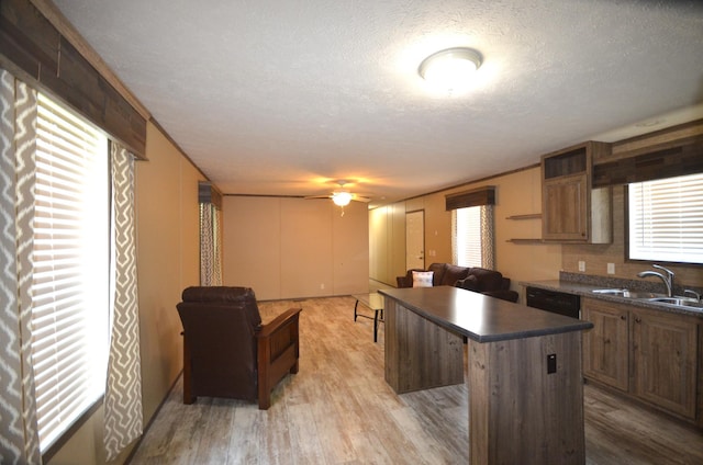 311 Mozart Ave E, Mankato, MN 56001 - kitchen featuring dark countertops, a kitchen island, plenty of natural light, light wood-style flooring, and a textured ceiling