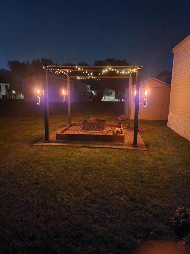 311 Mozart Ave E, Mankato, MN 56001 - yard at night featuring an outdoor fire pit, a lawn, and an outdoor structure