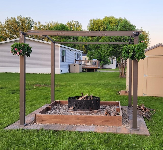 311 Mozart Ave E, Mankato, MN 56001 - view of grassy yard featuring a fire pit, a wooden deck, and a storage shed