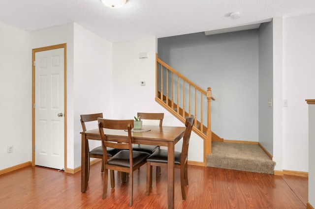 5055 149th St N Unit 2, Hugo, MN 55038 - dining space with wood finished floors, stairway, and a textured ceiling