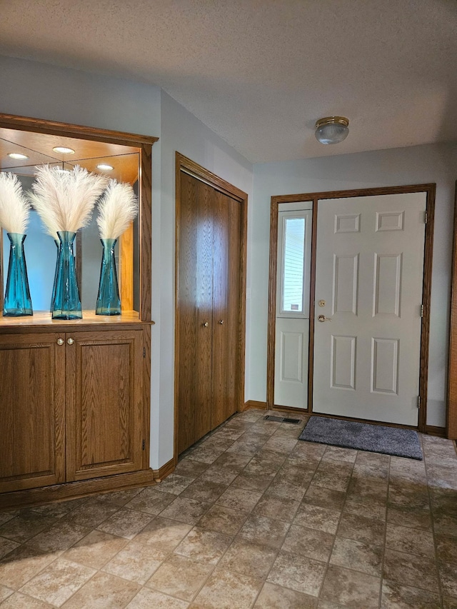 2705 9th St SW, Willmar, MN 56201 - entryway featuring a textured ceiling and light stone finish floors