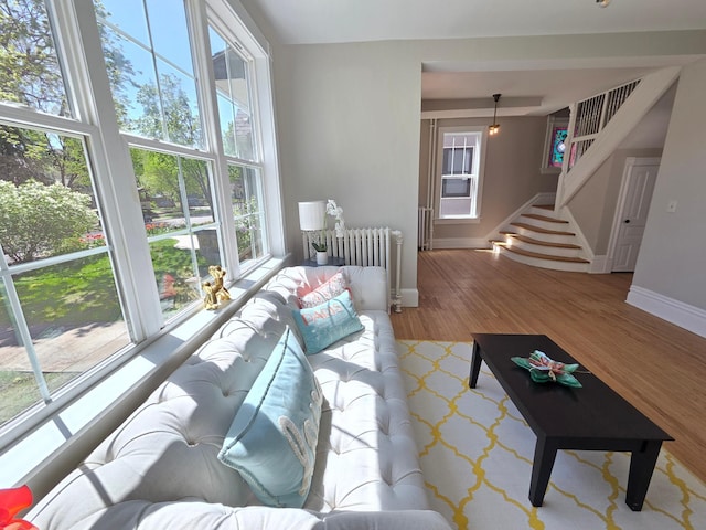 1323 Lincoln Ave, Saint Paul, MN 55105 - living room with radiator heating unit, baseboards, wood finished floors, and stairs