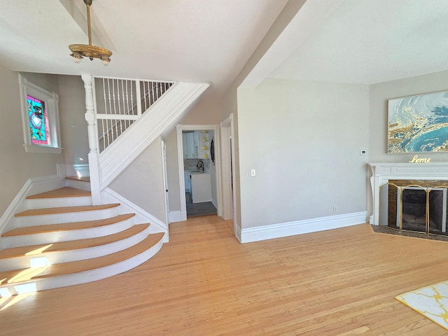 1323 Lincoln Ave, Saint Paul, MN 55105 - unfurnished living room featuring stairs, light wood-style floors, baseboards, and a fireplace