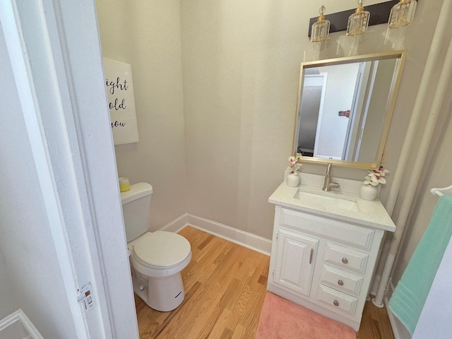 1323 Lincoln Ave, Saint Paul, MN 55105 - half bath featuring toilet, vanity, wood finished floors, and baseboards