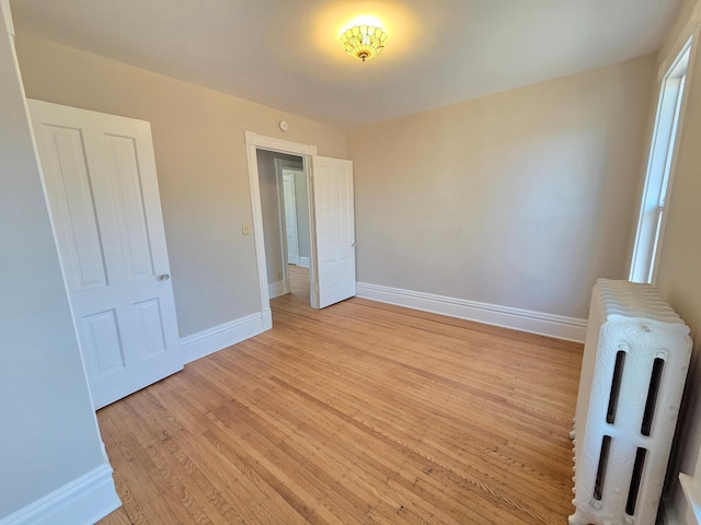 1323 Lincoln Ave, Saint Paul, MN 55105 - unfurnished bedroom featuring light wood finished floors, baseboards, and radiator