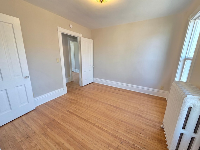 1323 Lincoln Ave, Saint Paul, MN 55105 - unfurnished bedroom featuring baseboards, light wood-style floors, and radiator