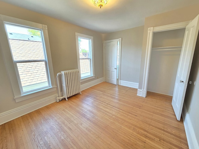 1323 Lincoln Ave, Saint Paul, MN 55105 - unfurnished bedroom with radiator heating unit, light wood finished floors, baseboards, and a closet