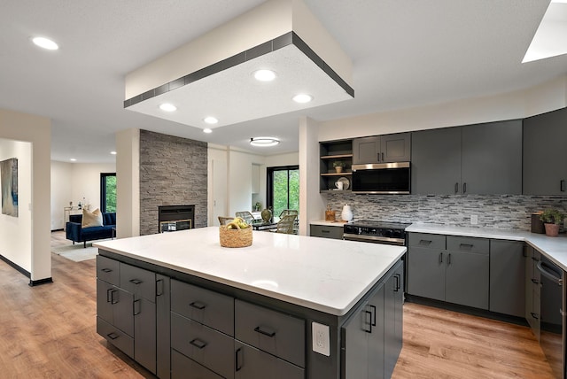 8335 Virginia Ave S, Bloomington, MN 55438 - kitchen featuring stainless steel appliances, gray cabinets, a kitchen island, decorative backsplash, and recessed lighting