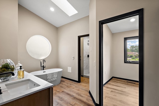 8335 Virginia Ave S, Bloomington, MN 55438 - bathroom with a skylight, a shower stall, a freestanding tub, wood finished floors, and lofted ceiling
