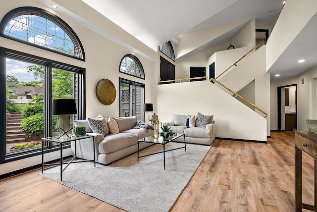 8335 Virginia Ave S, Bloomington, MN 55438 - living area featuring wood finished floors, a towering ceiling, stairway, and recessed lighting
