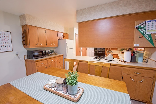 905 24th Ave N, Saint Cloud, MN 56303 - kitchen with black appliances, light countertops, and light wood finished floors