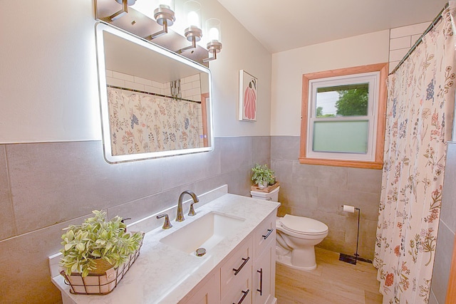 905 24th Ave N, Saint Cloud, MN 56303 - bathroom featuring vanity, tile walls, curtained shower, wood finished floors, and wainscoting