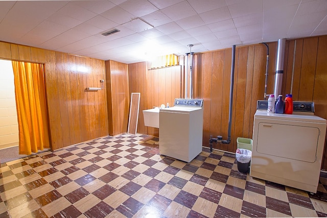 905 24th Ave N, Saint Cloud, MN 56303 - laundry room featuring washer and dryer, tile patterned floors, and wood walls