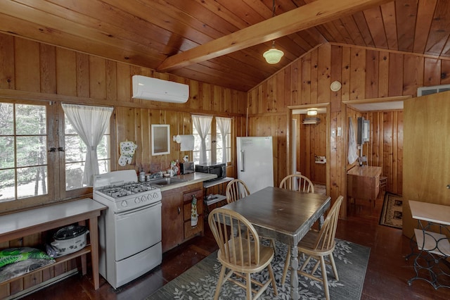 7520 Trophy Trl NW, Walker, MN 56484 - kitchen with gas range gas stove, a wall unit AC, freestanding refrigerator, wood walls, and dark wood-style floors