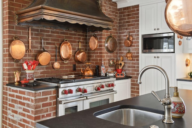11155 Mill Run, Minnetonka, MN 55305 - kitchen featuring appliances with stainless steel finishes, dark countertops, white cabinetry, and premium range hood
