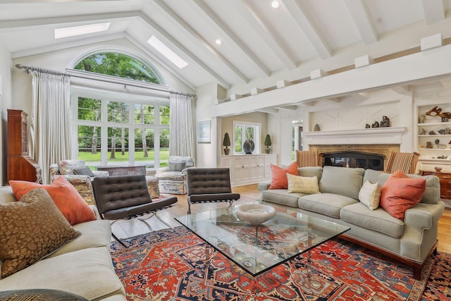 11155 Mill Run, Minnetonka, MN 55305 - living area featuring wood finished floors, a skylight, a glass covered fireplace, beam ceiling, and high vaulted ceiling