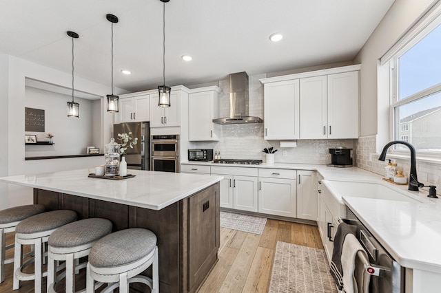 7872 Jade Ln, Victoria, MN 55386 - kitchen with wall chimney range hood, appliances with stainless steel finishes, a kitchen breakfast bar, decorative backsplash, and recessed lighting