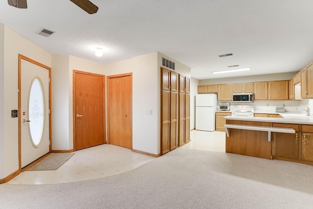 5645 Wisconsin Ave N, New Hope, MN 55428 - kitchen with white appliances, ceiling fan, a peninsula, light countertops, and light carpet
