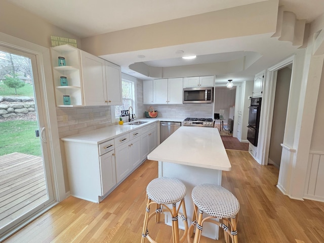 13801 Lake Street Ext, Minnetonka, MN 55345 - kitchen with stainless steel appliances, a sink, tasteful backsplash, light wood-style flooring, and light countertops