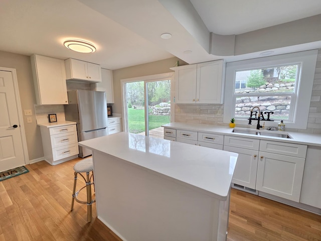 13801 Lake Street Ext, Minnetonka, MN 55345 - kitchen featuring freestanding refrigerator, a sink, light wood-type flooring, and backsplash