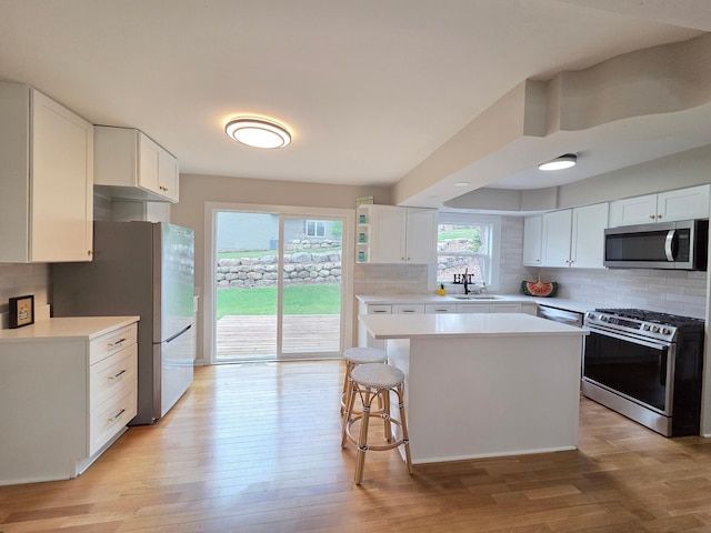 13801 Lake Street Ext, Minnetonka, MN 55345 - kitchen with appliances with stainless steel finishes, a sink, decorative backsplash, white cabinetry, and light countertops