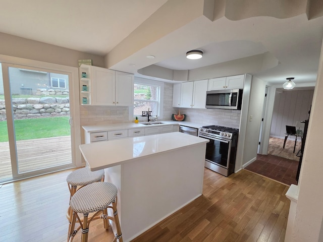 13801 Lake Street Ext, Minnetonka, MN 55345 - kitchen featuring appliances with stainless steel finishes, wood finished floors, decorative backsplash, white cabinetry, and light countertops