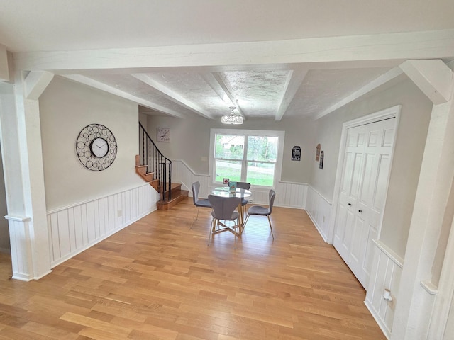 13801 Lake Street Ext, Minnetonka, MN 55345 - dining space featuring beam ceiling, light wood-type flooring, stairway, wainscoting, and a decorative wall