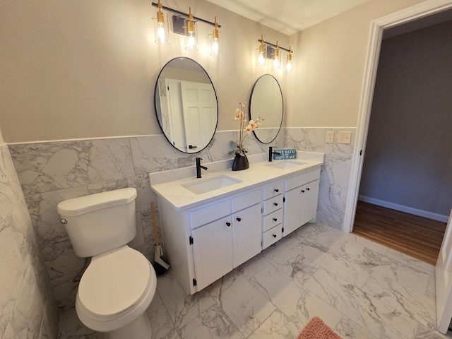 13801 Lake Street Ext, Minnetonka, MN 55345 - full bathroom with tile walls, double vanity, wainscoting, toilet, and marble finish flooring