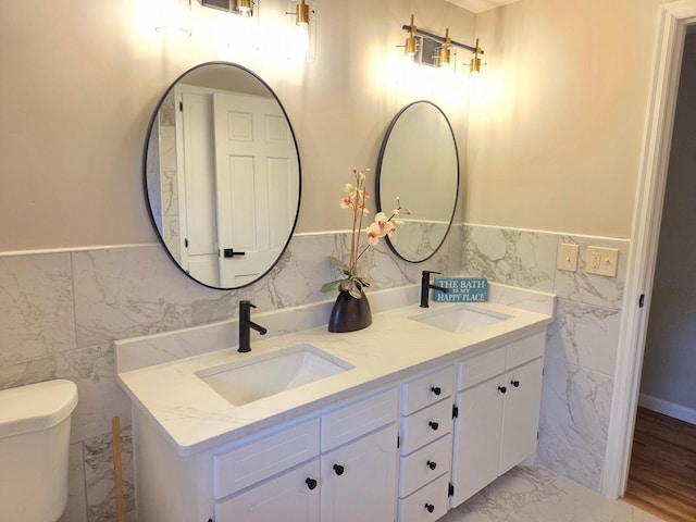 13801 Lake Street Ext, Minnetonka, MN 55345 - full bathroom featuring tile walls, double vanity, toilet, wainscoting, and marble finish flooring